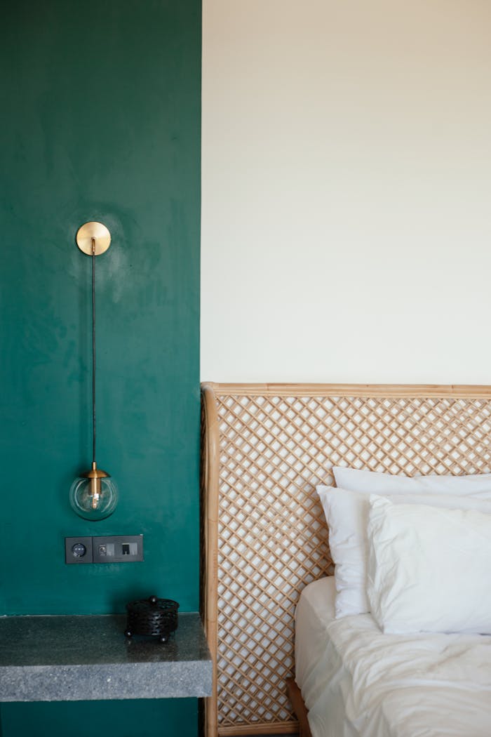 Modern bedroom featuring a stylish green accent wall and cozy bed setup.